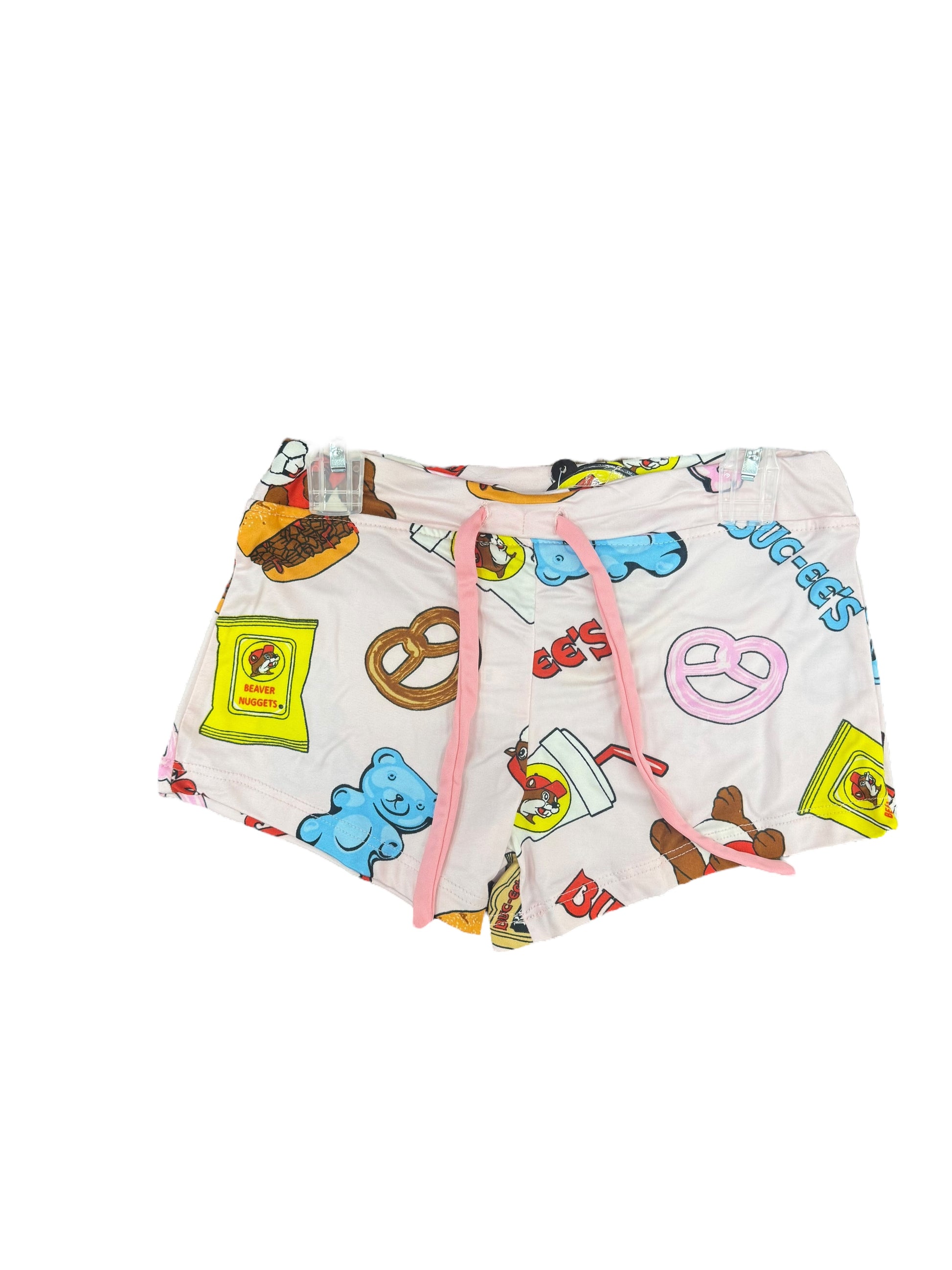 Buc-ee’s pajama shorts with snack-themed print, elastic waistband, and pink drawstring featuring Beaver Nuggets, drinks, gummy bears, and pretzels